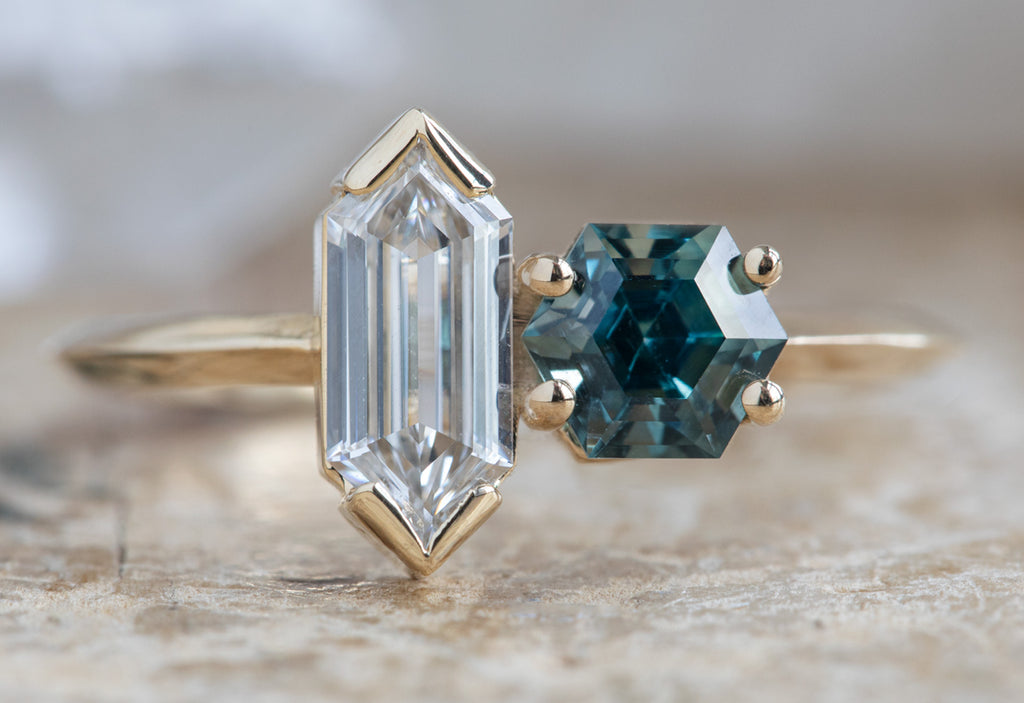 'You & Me' Ring with a Hexagon Diamond + Sapphire on Wood Table